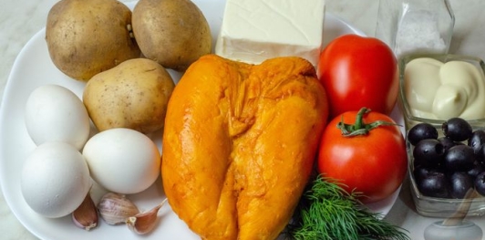 Салат с копчёной курицей, овощами, плавленым сыром, яйцами и маслинами