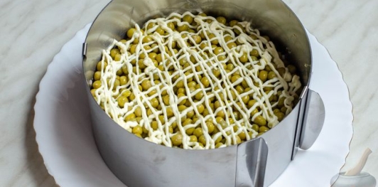 Слоёный салат с ветчиной, сыром, яйцами и зелёным горошком
