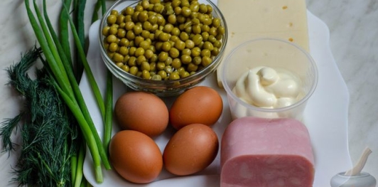 Слоёный салат с ветчиной, сыром, яйцами и зелёным горошком