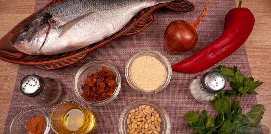 Фаршированная дорада с изюмом и орехами, запечённая со сладким перцем